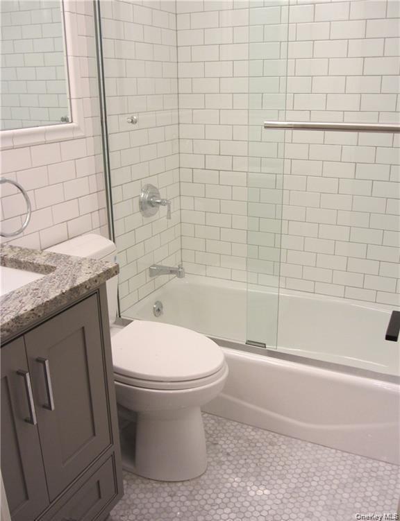 17 Cedar Street, Unit 3 Dobbs Ferry, NY 10522 - Photo 4 of 7 a bathroom with a granite countertop toilet a sink and bathtub