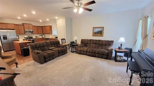 a living room with furniture kitchen view and a window