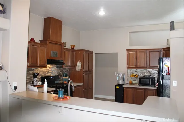 a kitchen with stainless steel appliances kitchen island granite countertop a refrigerator and stove