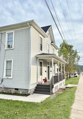 a view of a white house with a big yard and large windows