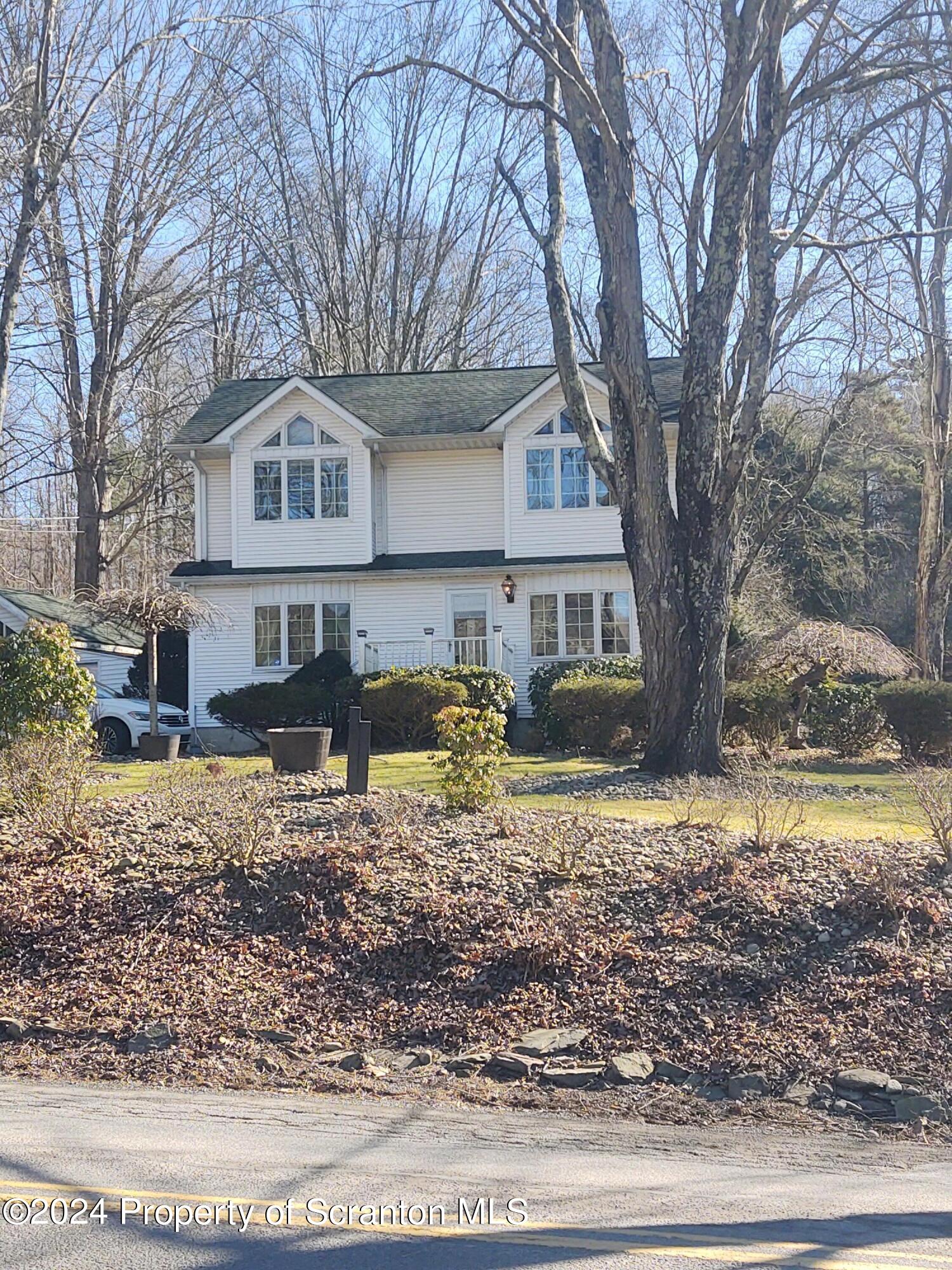 2401 Chase Road Shavertown, PA 18708 - Photo 2 of 19 a front view of a house with a yard covered with trees