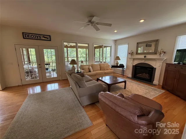 a living room with furniture a fireplace and a floor to ceiling window