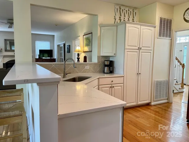 a kitchen with kitchen island a counter top space a sink a refrigerator and a stove