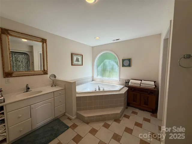 a bathroom with a bathtub sink and mirror