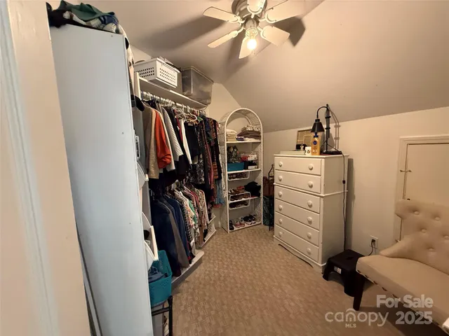 a view of walk in closet with clothes and shoes