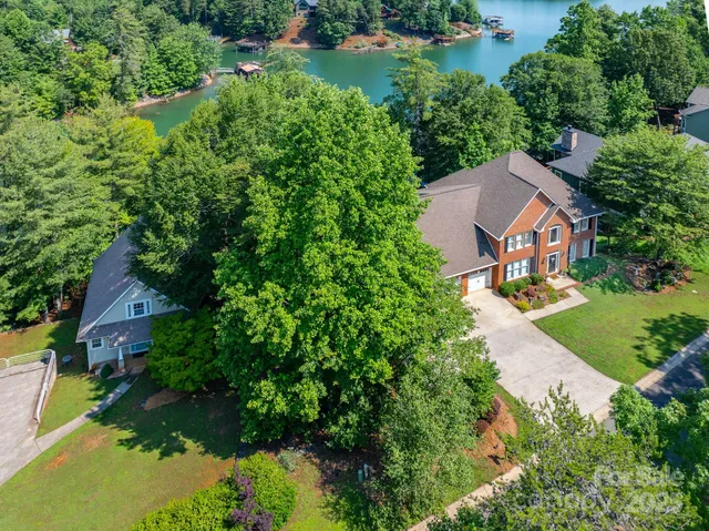 an aerial view of residential house with outdoor space and trees all around