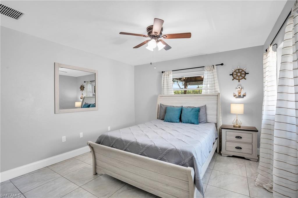 130 Mentor Drive Naples, FL 34110 - Photo 22 of 47 a bedroom with a bed and a chandelier