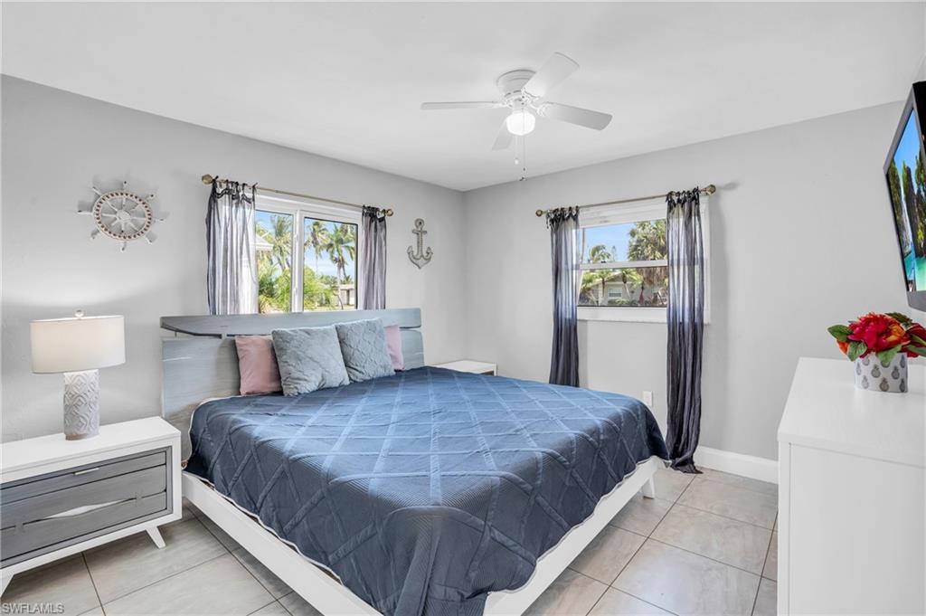 130 Mentor Drive Naples, FL 34110 - Photo 24 of 47 a bedroom with a large bed and a chandelier