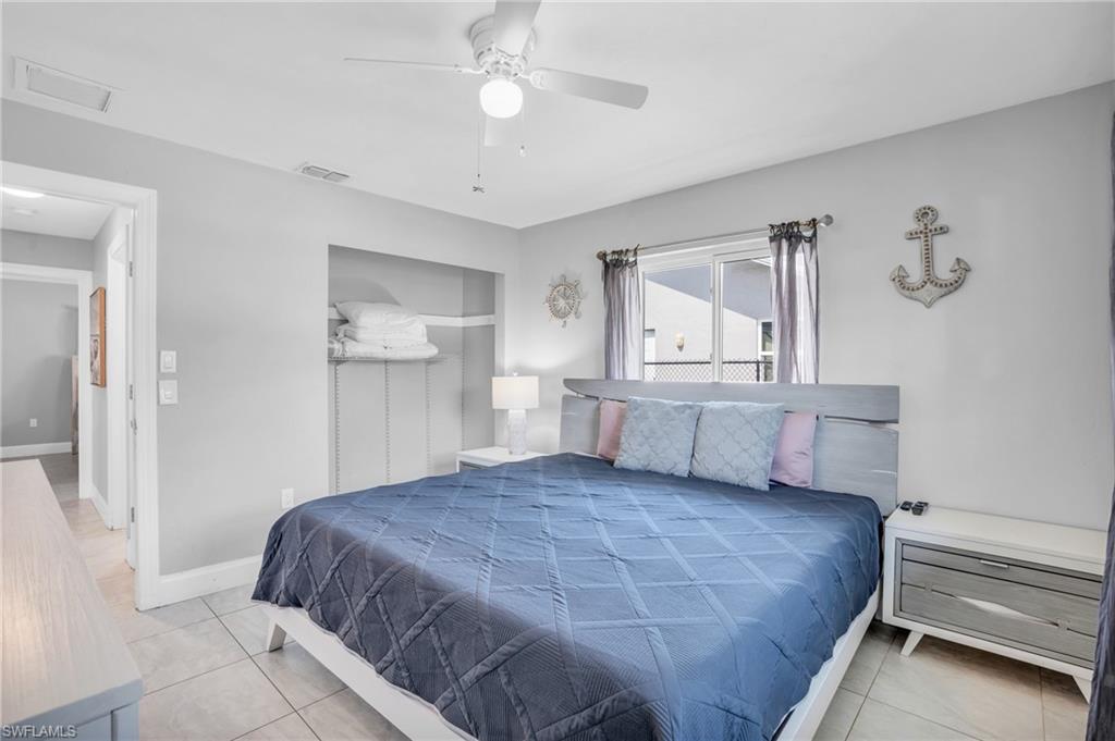 130 Mentor Drive Naples, FL 34110 - Photo 25 of 47 a bedroom with a large bed and a chandelier