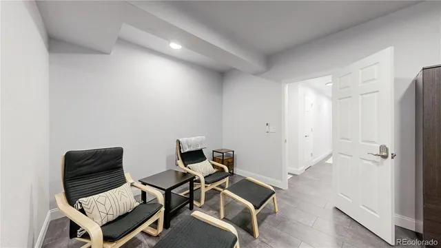 a view of a room with chairs and wooden floor