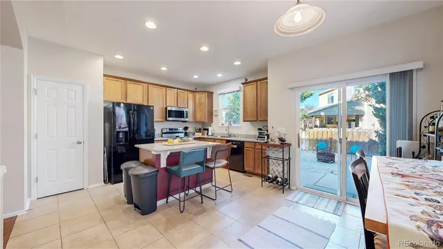 a view of kitchen with refrigerator stove dining table and chairs