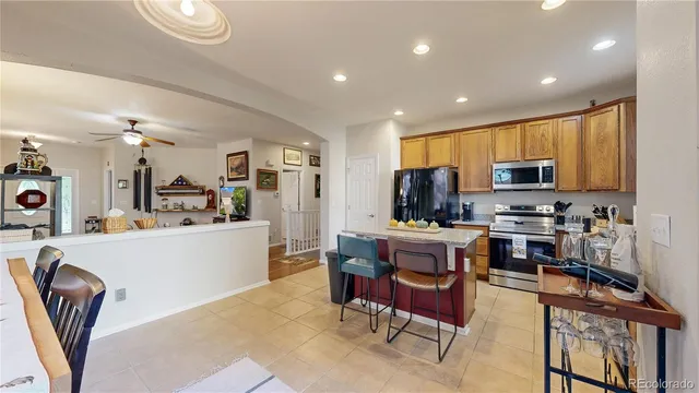 a view of kitchen with stainless steel appliances granite countertop a stove top oven a sink a dining table and chairs with wooden floor