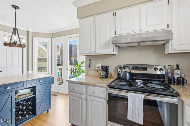 a kitchen with stainless steel appliances granite countertop a stove a sink and a white cabinets