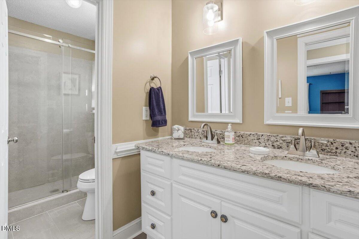 3516 East Jameson Road Raleigh, NC 27604 - Photo 16 of 32 a bathroom with a granite countertop sink toilet and shower