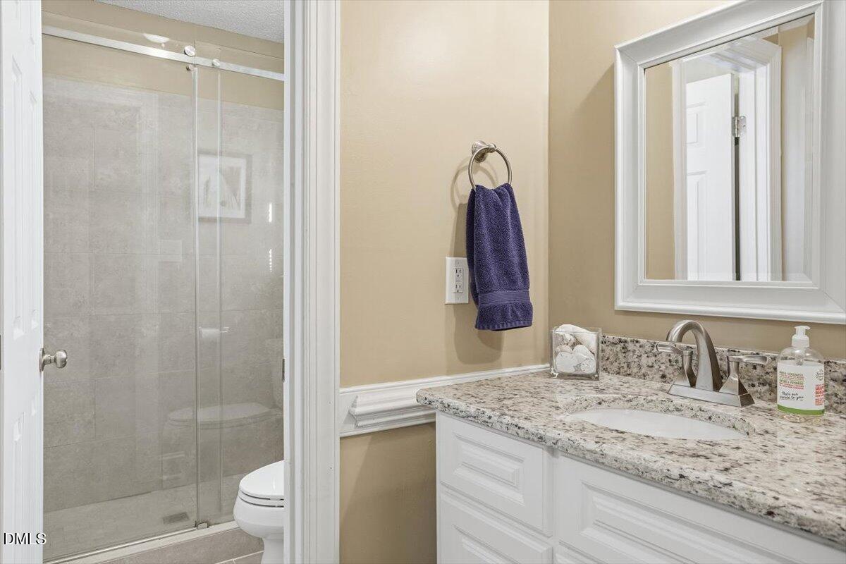 3516 East Jameson Road Raleigh, NC 27604 - Photo 17 of 32 a bathroom with a granite countertop sink and a mirror