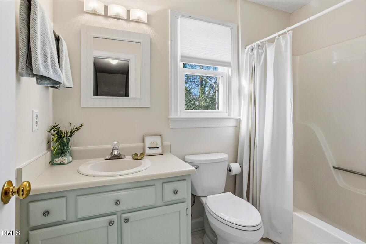 3516 East Jameson Road Raleigh, NC 27604 - Photo 24 of 32 a bathroom with a sink a mirror a toilet and window