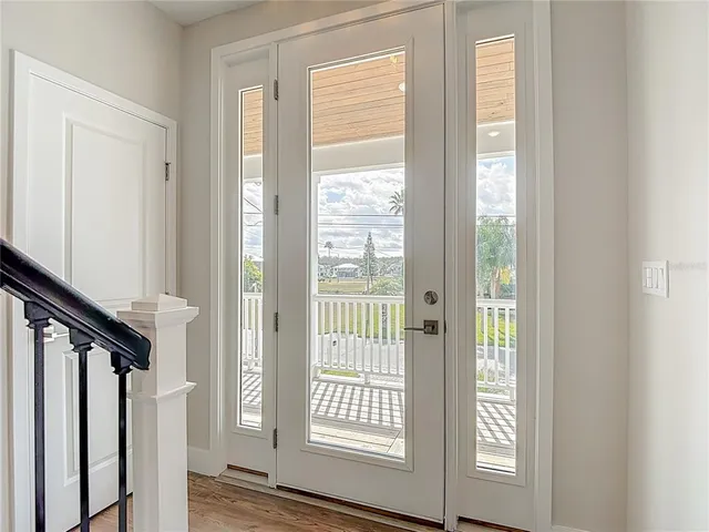 an empty room with wooden floor ceiling fan and windows