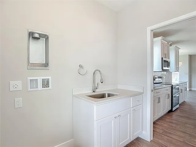a bathroom with a granite countertop double vanity sink a mirror and with