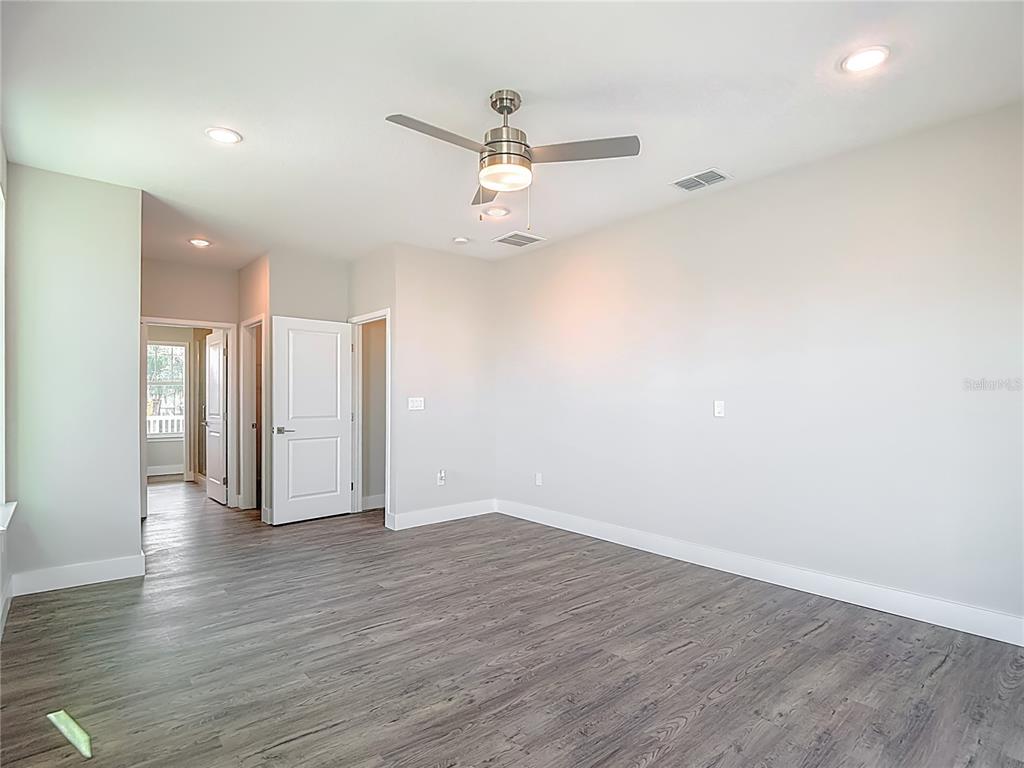 3487 Sheephead Drive Hernando Beach, FL 34607 - Photo 54 of 77 an empty room with wooden floor ceiling fan and windows