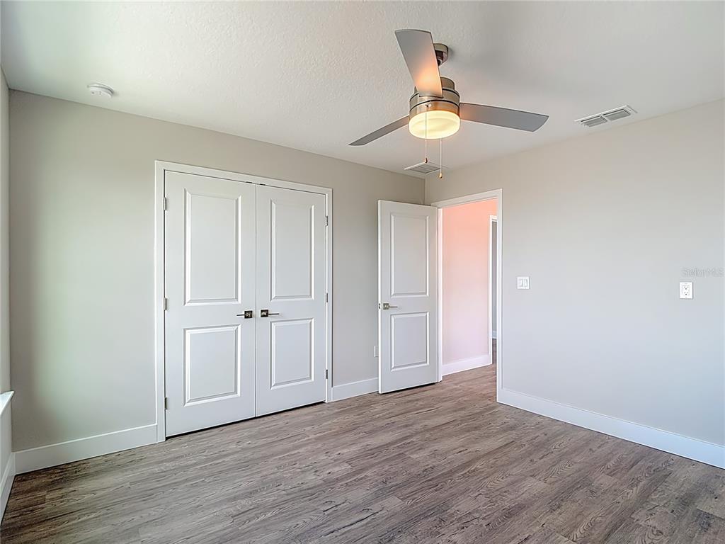 3487 Sheephead Drive Hernando Beach, FL 34607 - Photo 69 of 77 an empty room with wooden floor ceiling fan and windows
