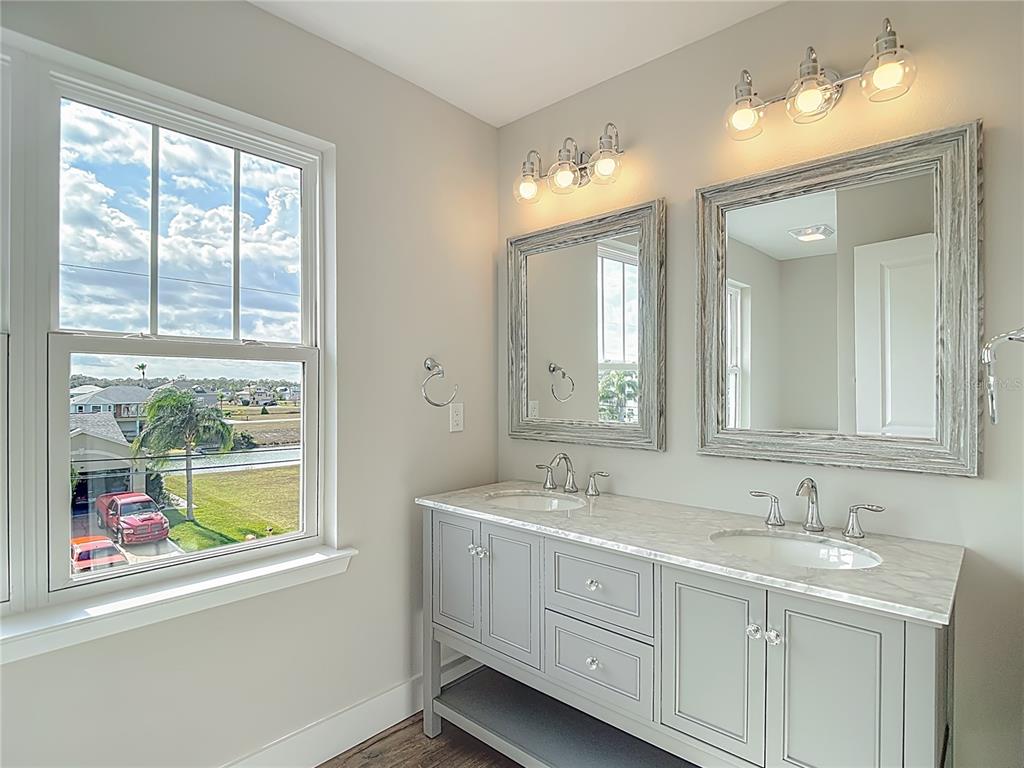 3487 Sheephead Drive Hernando Beach, FL 34607 - Photo 73 of 77 a bathroom with a double vanity sink and a mirror