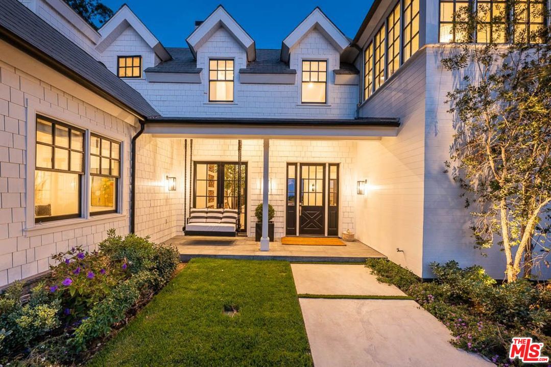 6950 Dume Drive Malibu, CA 90265 - Photo 22 of 24 a view of a brick house with a large windows and flower plants