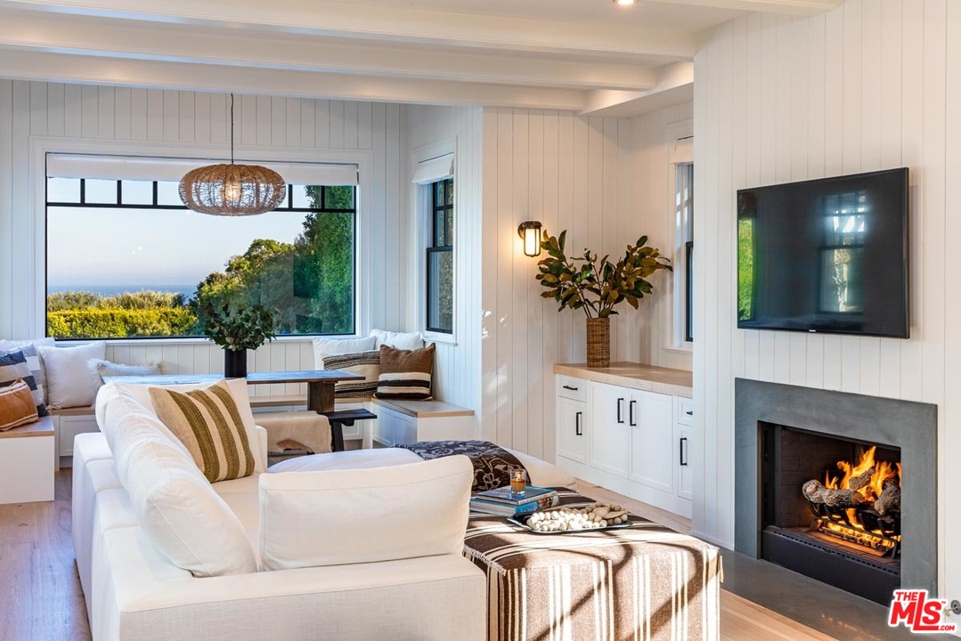 6950 Dume Drive Malibu, CA 90265 - Photo 8 of 24 a living room with furniture a fireplace and a flat screen tv