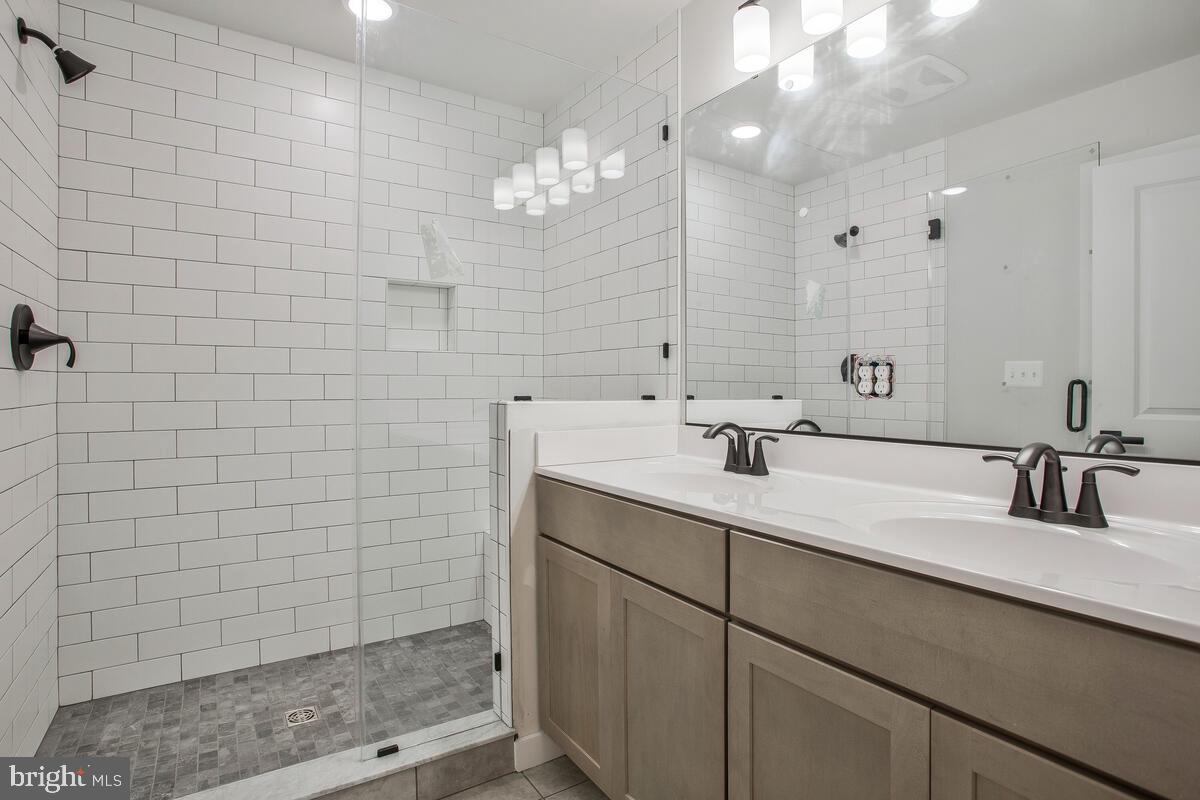 1209 Johnson Drive Shady Side, MD 20764 - Photo 16 of 37 a bathroom with a sink a large mirror and shower