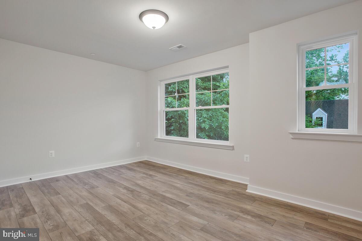 1209 Johnson Drive Shady Side, MD 20764 - Photo 20 of 37 an empty room with wooden floor and windows