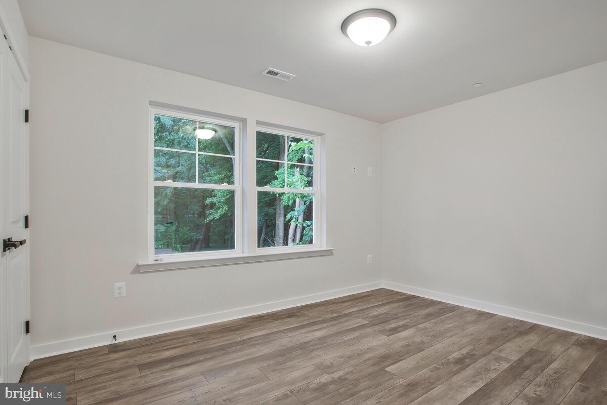 1209 Johnson Drive Shady Side, MD 20764 - Photo 24 of 37 an empty room with wooden floor and windows