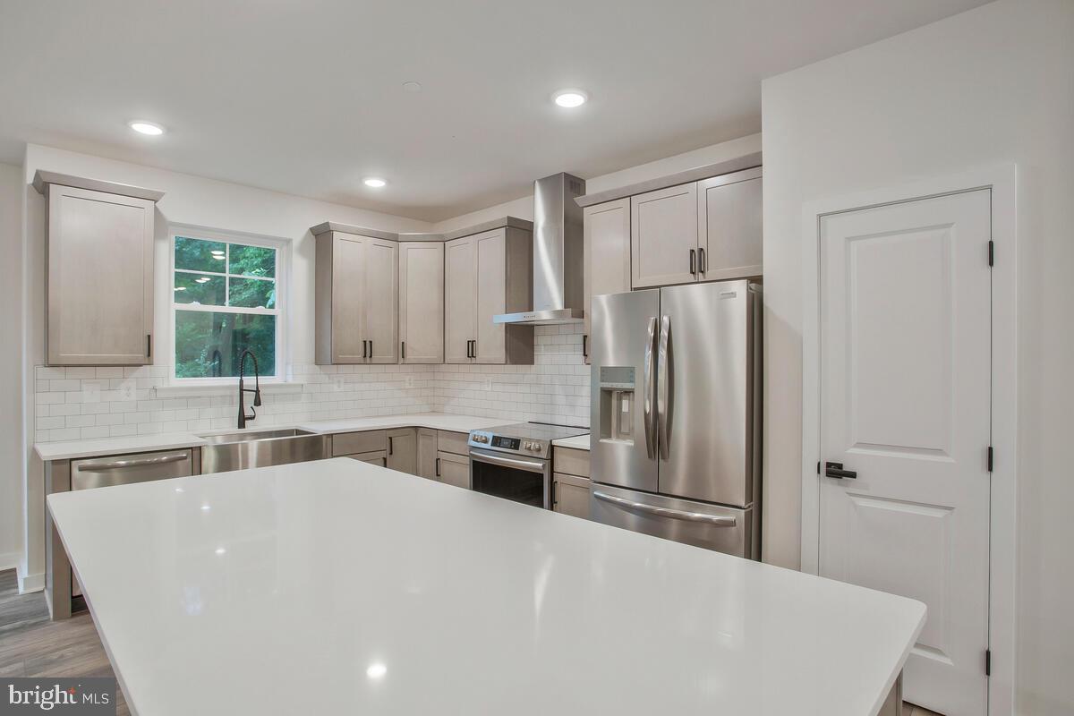 1209 Johnson Drive Shady Side, MD 20764 - Photo 3 of 37 a large white kitchen with a refrigerator a sink stainless steel appliances and cabinets
