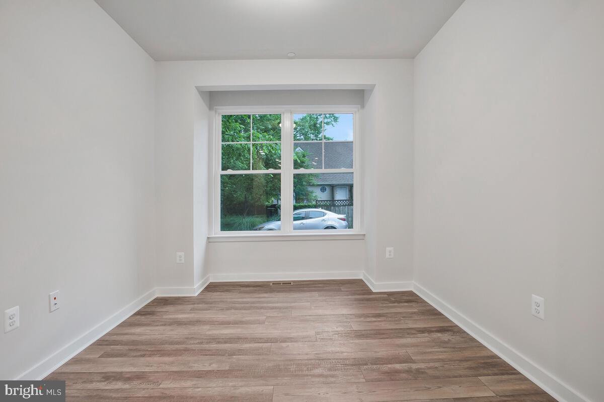 1209 Johnson Drive Shady Side, MD 20764 - Photo 9 of 37 a view of an empty room with wooden floor and a window