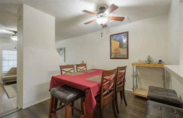 a view of a dining room with furniture and a chandelier fan