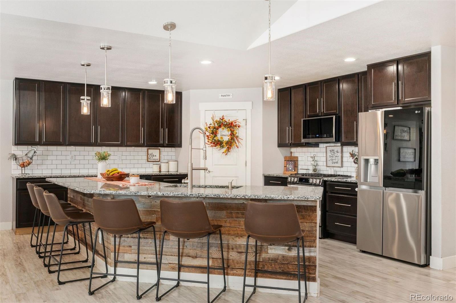 16477 Stoneleigh Road Platteville, CO 80651 - Photo 7 of 37 a kitchen with stainless steel appliances granite countertop a stove top oven a refrigerator a sink and chairs