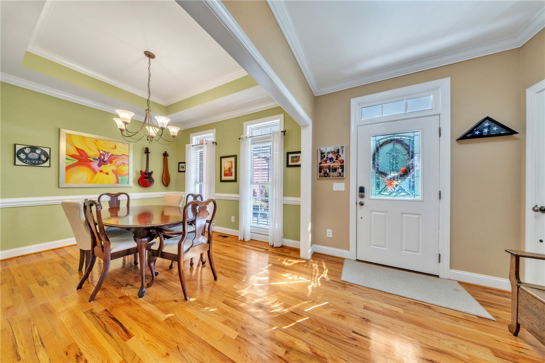 648 Mountain View Road Williamston, SC 29697 - Photo 2 of 42 Hardwood floors stretch across this inviting dining area, illuminated by natural light and a classic chandelier.