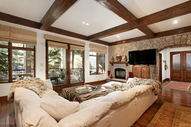 a large bedroom with a large bed flat screen tv and a fireplace