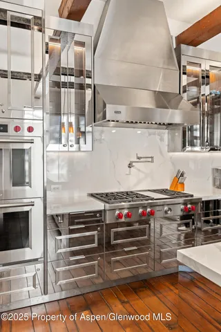 a kitchen with stainless steel appliances and wooden floor