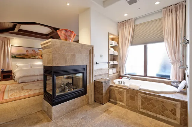 a living room with stainless steel appliances granite countertop furniture and a fireplace