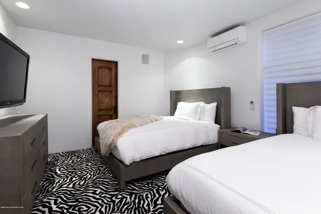 a bedroom with two beds and a flat screen tv