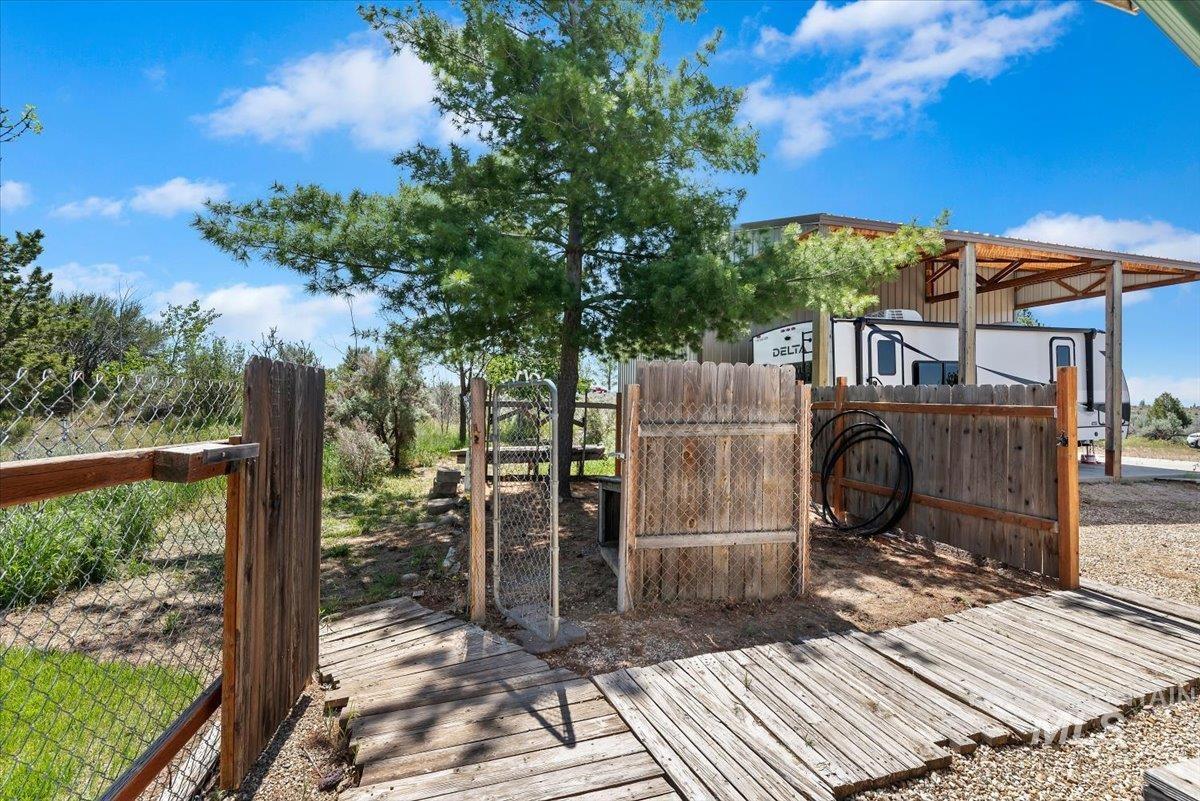 147 East Indian Crk Road Boise, ID 83716 - Photo 33 of 43 Expansive outdoor area featuring a wide wooden pathway, chain-link fencing, and a built-in wooden structure