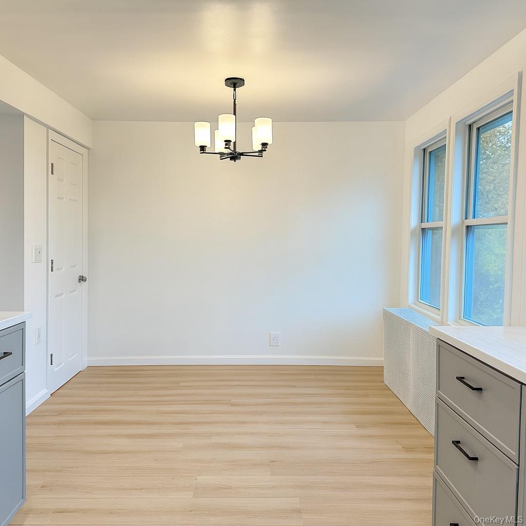 88 Cold Spring Road Liberty, NY 12754 - Photo 11 of 32 Unfurnished dining area with light wood finished floors and a chandelier