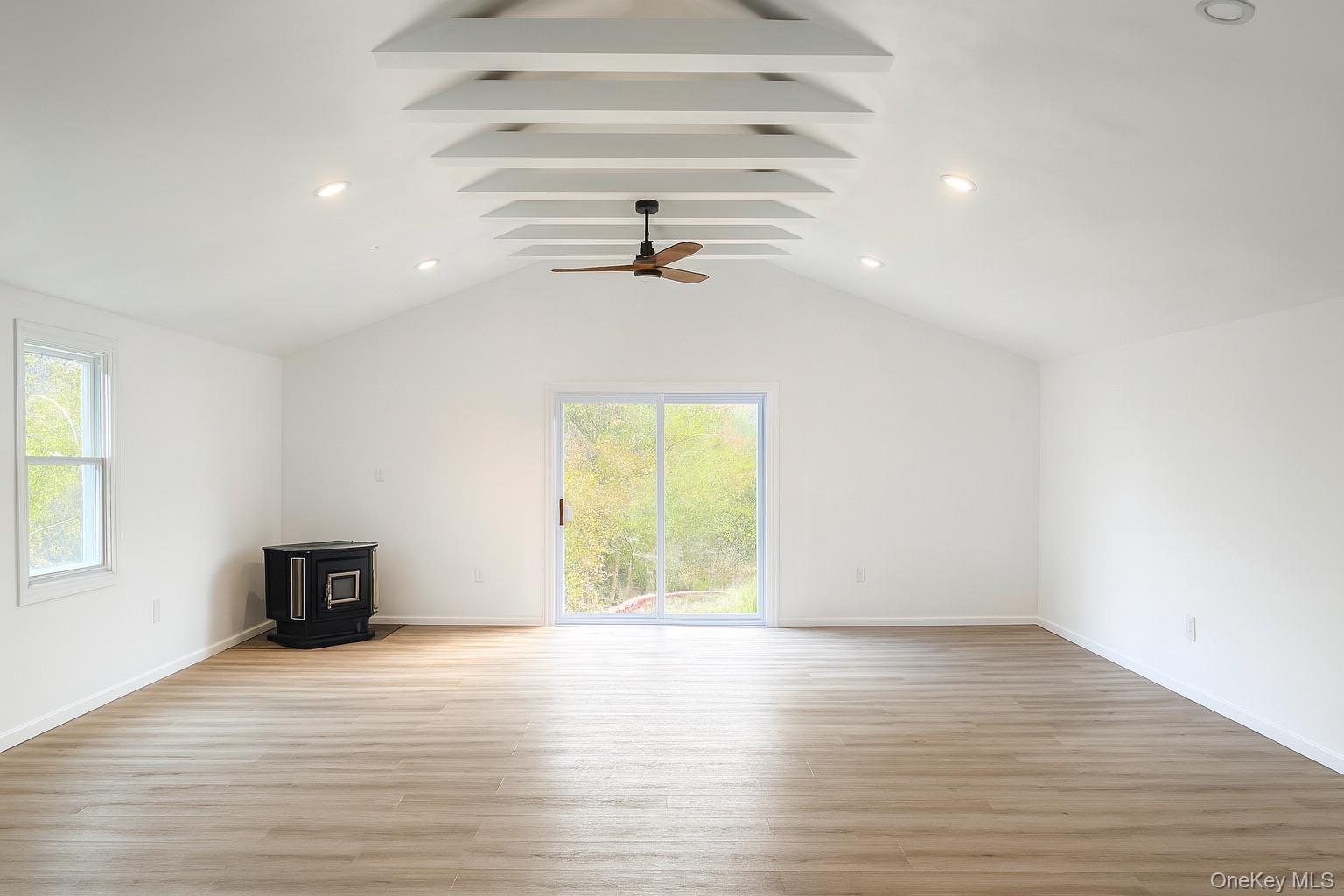 88 Cold Spring Road Liberty, NY 12754 - Photo 28 of 32 Unfurnished living room featuring a wood stove, healthy amount of natural light, lofted ceiling, light wood finished floors, and recessed lighting