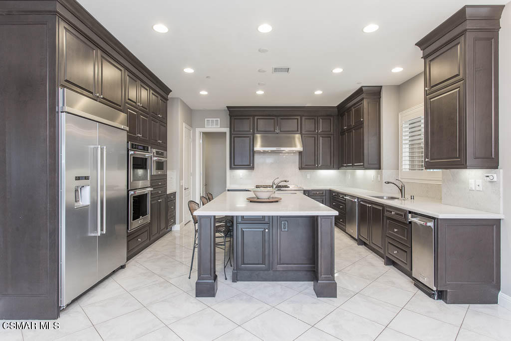 7342 Nicklaus Road Moorpark, CA 93021 - Photo 16 of 55 a kitchen with kitchen island granite countertop a sink stove and refrigerator