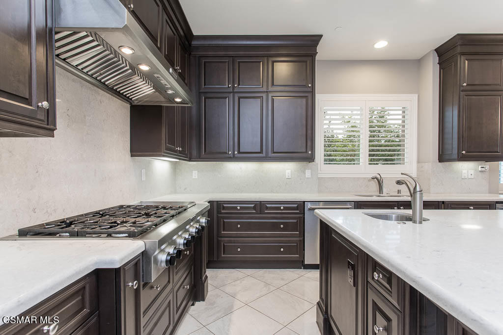 7342 Nicklaus Road Moorpark, CA 93021 - Photo 19 of 55 a kitchen with stainless steel appliances granite countertop a sink stove and cabinets