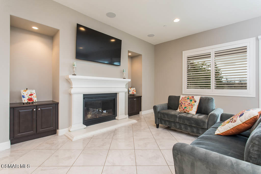 7342 Nicklaus Road Moorpark, CA 93021 - Photo 25 of 55 a living room with furniture a fireplace and a flat screen tv