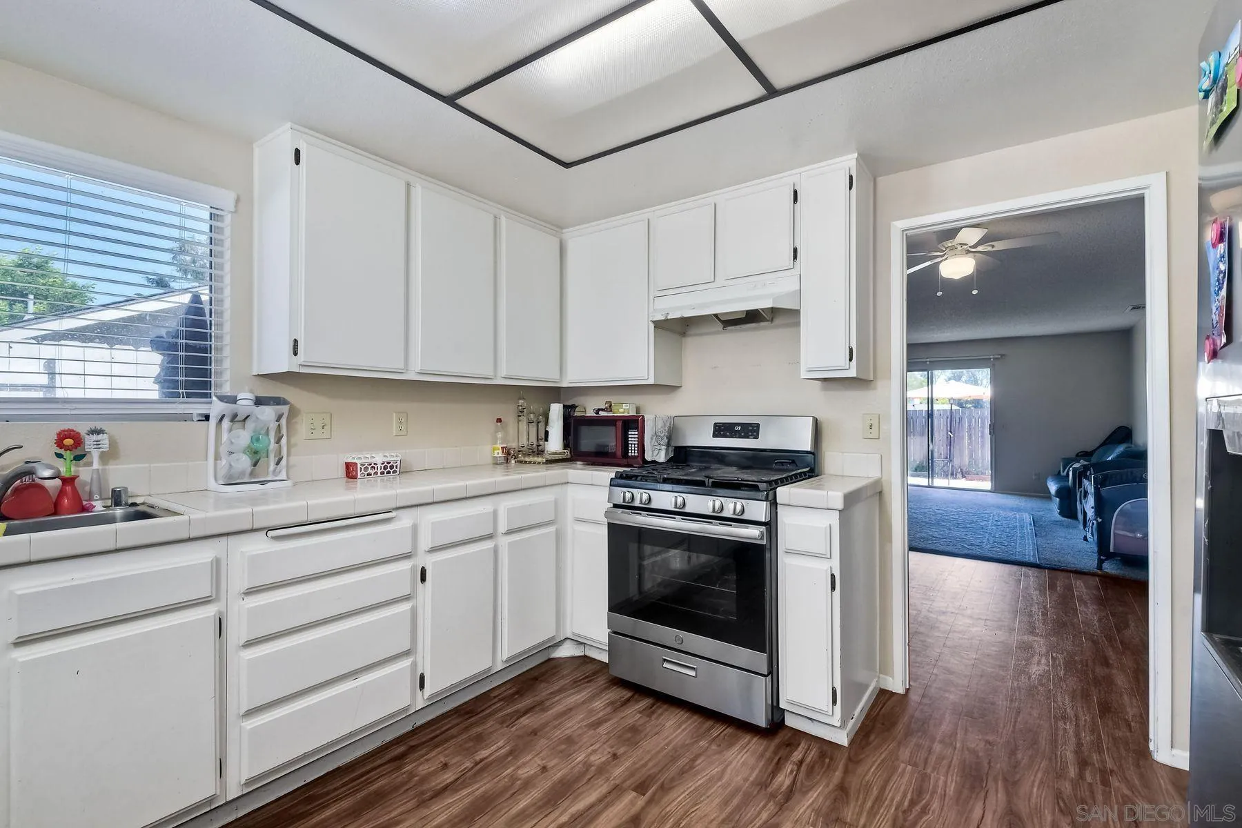 1160 Corral Glen Escondido, CA 92026 - Photo 8 of 16 a kitchen with stainless steel appliances granite countertop a stove and white cabinets