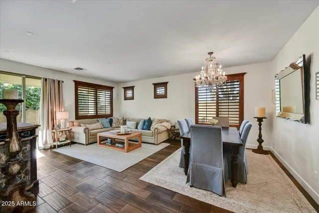 a living room with furniture two window and a flat screen tv