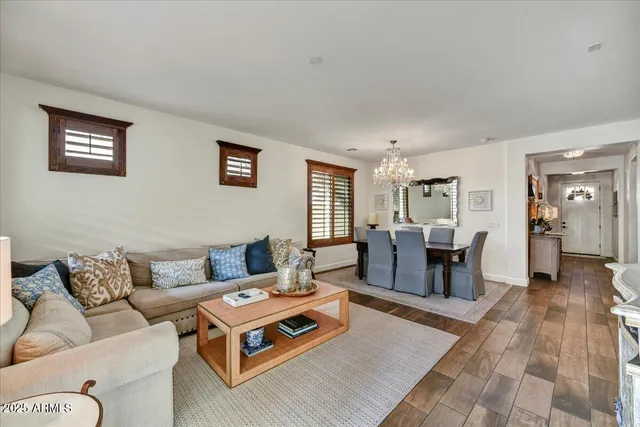 a living room with furniture a dining table and chairs with wooden floor