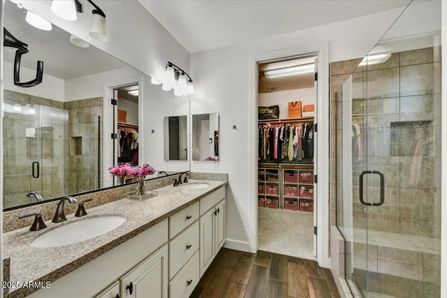 a bathroom with a granite countertop shower sink and mirror