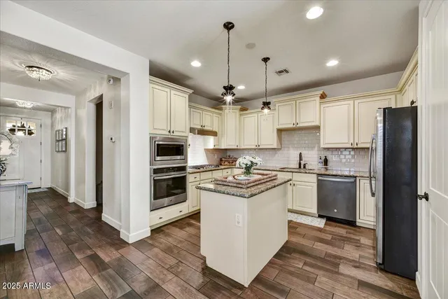 a kitchen with stainless steel appliances granite countertop a stove a refrigerator and a sink